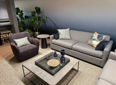 Cambridge Lounge seating with a gray sofa, upholstered armchair, and glass coffee table.